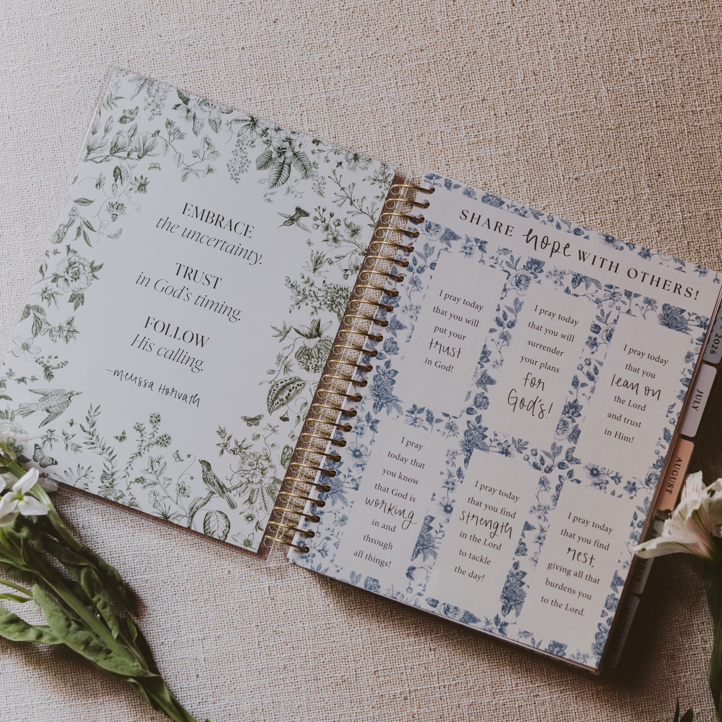 Open spiral-bound notebook with floral and text design on a textured surface