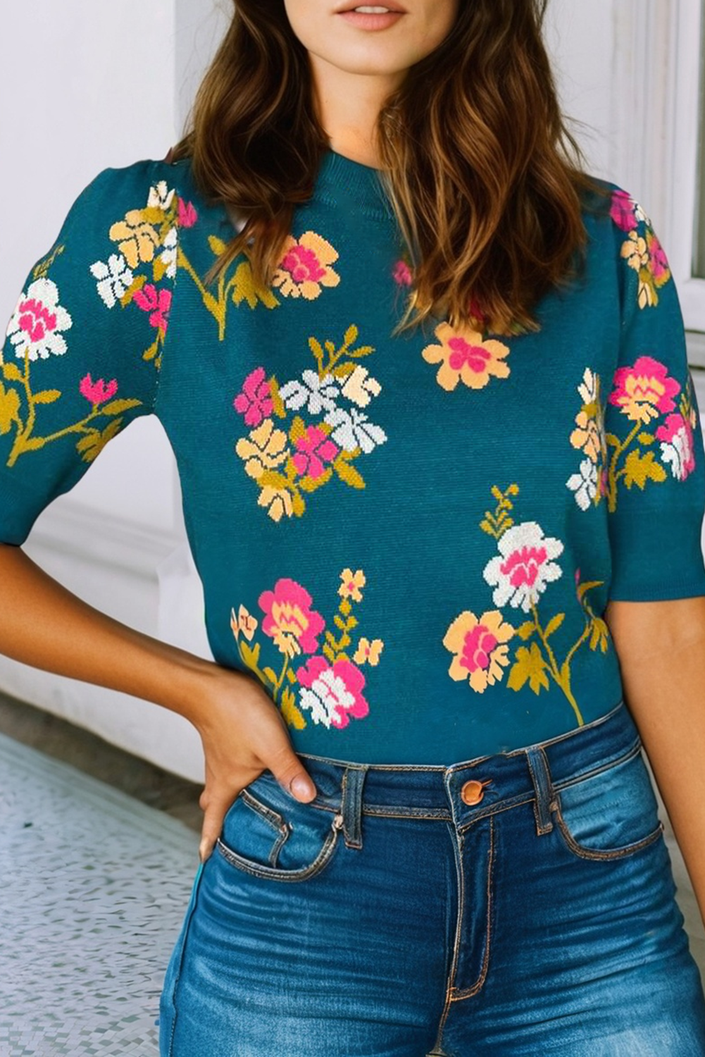 Person wearing a teal floral top with a blurred background