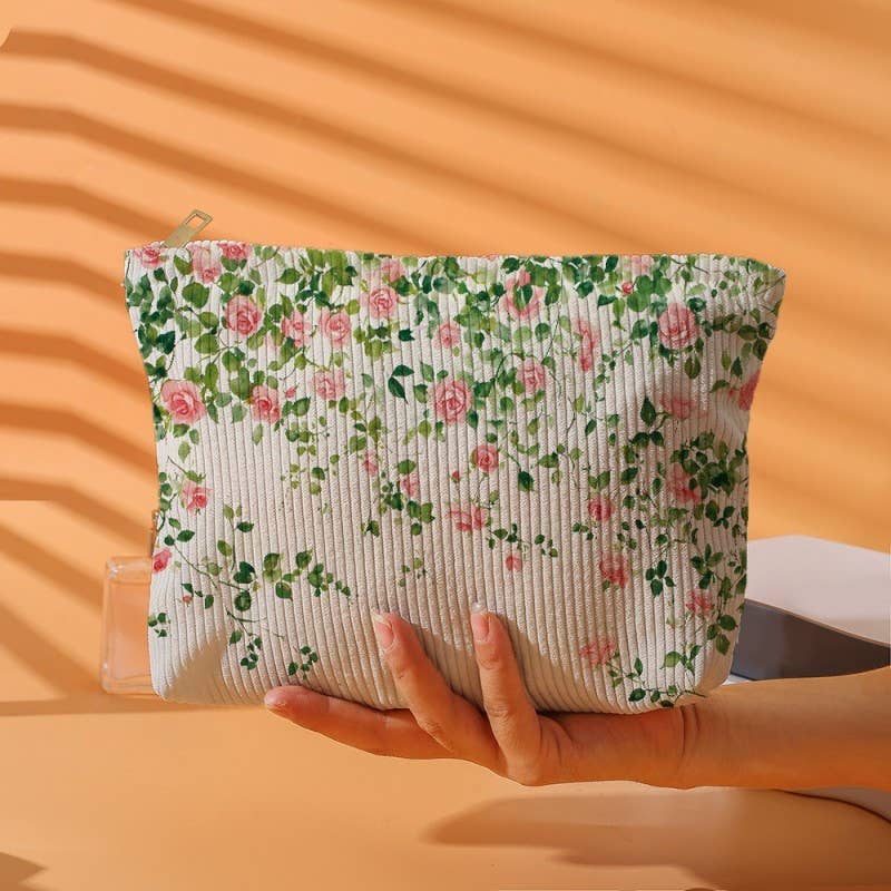 Floral-patterned pouch held by a hand against an orange background