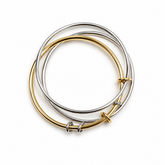 Two gold and silver bangles stacked on a white background
