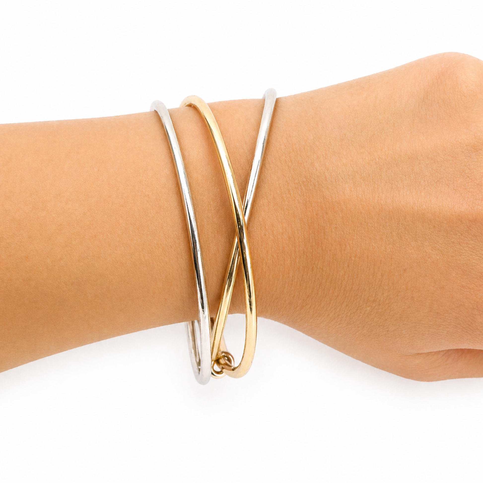 Gold bangle on a wrist against a white background