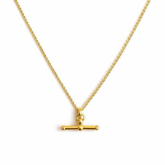 Gold necklace with a small pendant on a white background