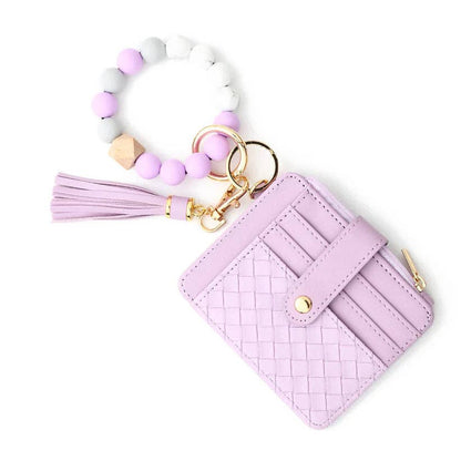 Pink woven cardholder with tassel keychain on a white background